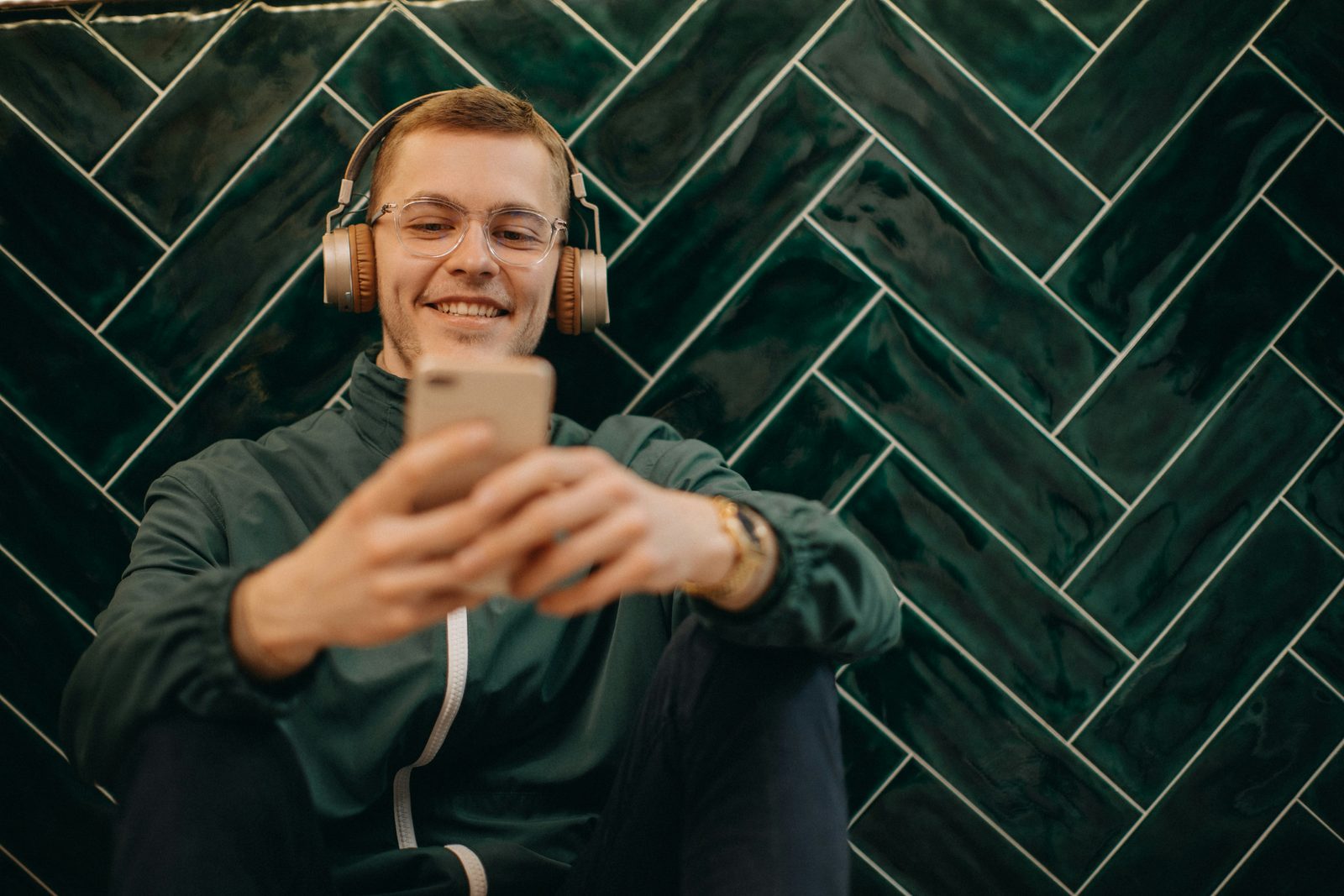 Muž se sluchátky si prochází svůj audit v telefonu
